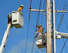 line workers in buckets at utility pole
